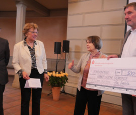 Matthias Finken (links) und Fides Mahrla vom Kulturstadt Potsdam e.V. überreichen eine Spende an Regina Milkereit und Torsten Rüdinger von der Französischen Reformierten Gemeinde Potsdam.